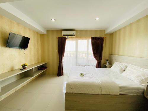 SunggalHozby Skyview Setiabudi的卧室配有一张床,墙上配有电视。