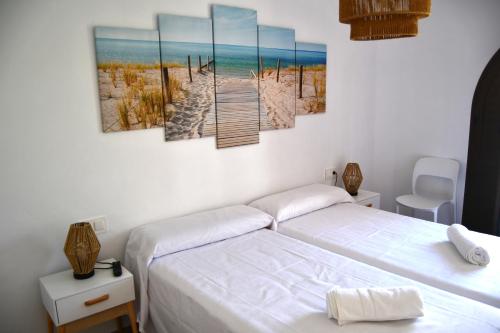米拉马尔Casa VALOLI PLAYA MIRAMAR的一间卧室设有两张床,还有一条通往海滩的木板路