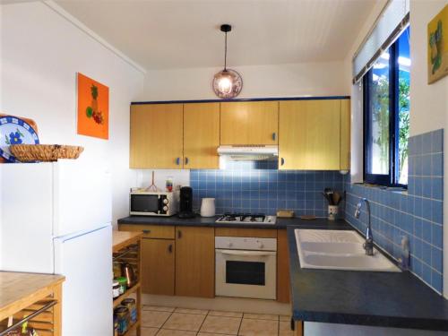 帕皮提TAHITI - Studio Te Maraamu的厨房配有水槽和炉灶 顶部烤箱