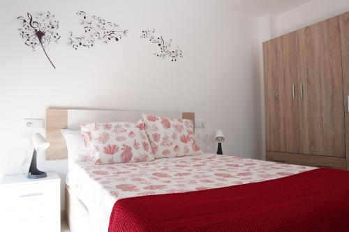圣罗克APARTAMENTOS TURÍSTICOS SAN MIGUEL ARCÁNGEL, S.L.的一间卧室配有一张红色棉被的床