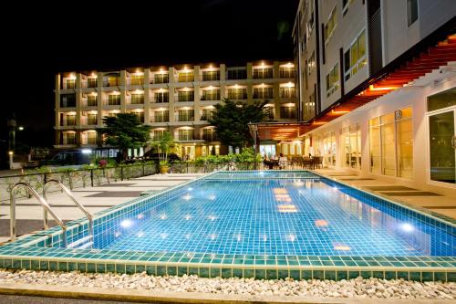 莱卡邦Sinsuvarn Airport Suite Hotel SHA Extra Plus Certified B5040的一座游泳池,在晚上在建筑物前