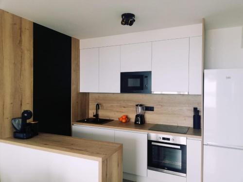 杜基拉特Apartman Aria的厨房配有白色橱柜和白色冰箱。
