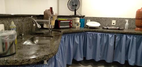 维拉维尔哈KITNET COM GARAGEM BARRA DO JUCU的厨房配有水槽和带毛巾的台面