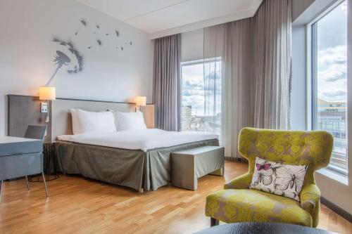 乌普萨拉乌普萨拉丽笙布鲁酒店的配有一张床和一把椅子的酒店客房