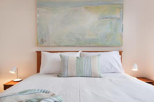 昆斯克利夫所特阁楼公寓的一张带两个枕头的白色床和绘画
