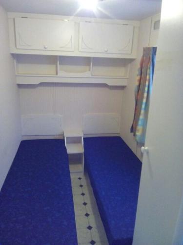 PozezdrzeEAGLE BIWAK的小房间设有蓝色地板和白色橱柜