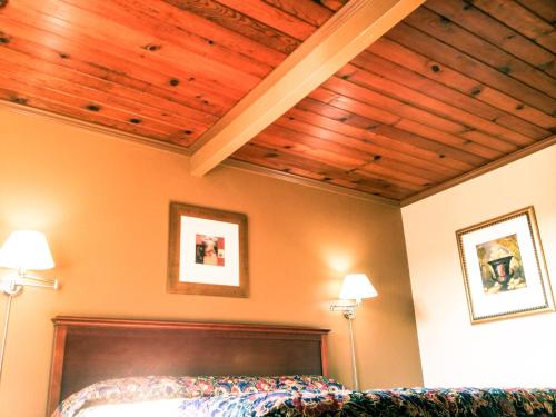伯克利海滨酒店的一间卧室设有床铺和木制天花板