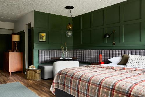 亨特Hunter Lodge, a Bluebird by Lark的一间卧室设有绿色的墙壁、一张床和一张桌子