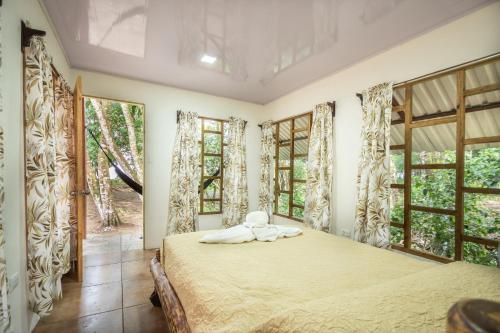 德雷克Playa Ganadito Ecolodge的一间设有床铺的卧室,位于带窗户的房间内
