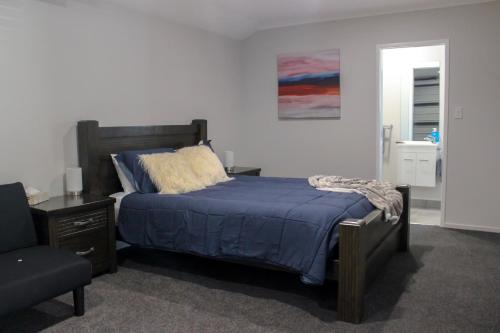 纳皮尔City Centre Escape的一间卧室配有一张带蓝色被子和椅子的床