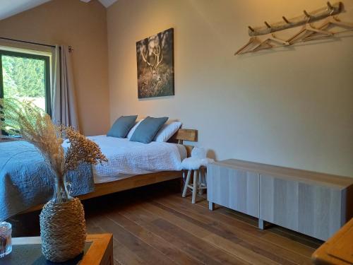 斯图蒙Le Clos du Cerf - Silence & nature的一间卧室配有一张带蓝色枕头的床和一扇窗户。