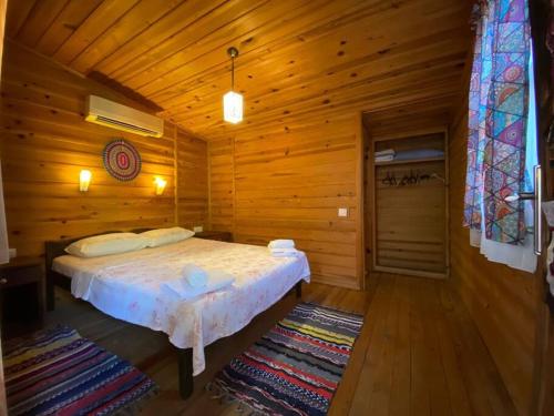 费特希耶Tiny House Ceviz Kayaköy Jungle Camping的小木屋内一间卧室,配有一张床