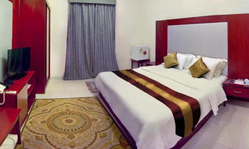 吉达Al Farhan Apartment Al Hamra-Jeddah的酒店客房设有一张大床和一台电视。