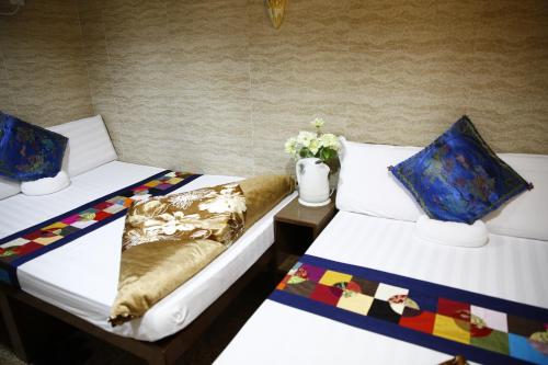 香港Sandhu Guest House的两张睡床彼此相邻,位于一个房间里