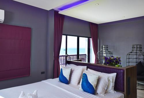 芭堤雅市中心The Weekend Pattaya (Tweet Tweet Nest Pattaya)的一间卧室配有一张带蓝色和白色枕头的床