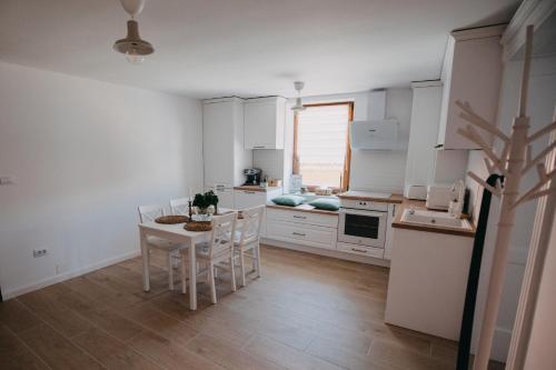 布拉索夫Studio Manzur的厨房配有白色橱柜和桌椅