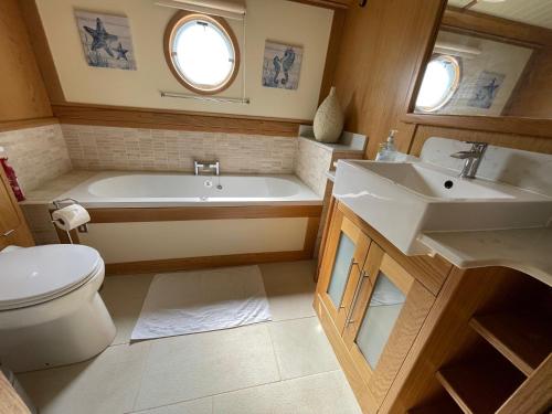 阿克斯桥Luxury boat - The Thistle Dream的带浴缸、卫生间和盥洗盆的浴室