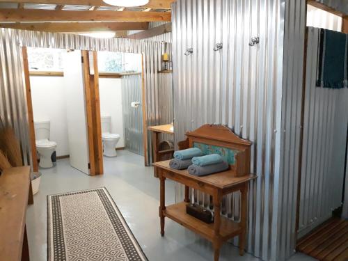 斯托姆勒菲Storms River Tin House的浴室设有2个卫生间和1张带毛巾的桌子