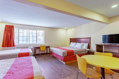 彭德尔顿Motel 6 Pendleton, OR - West的一间酒店客房,设有两张床、一张桌子和一台电视机