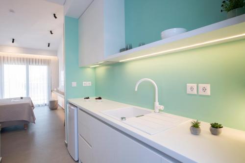 尼基亚娜Elianthi Luxury Apartments的厨房配有白色水槽和蓝色的墙壁