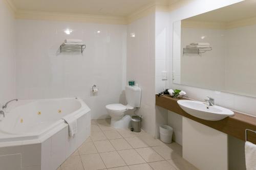 诺曼维尔Lady Bay Hotel的带浴缸、盥洗盆和卫生间的浴室