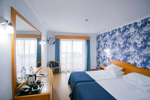 波瓦桑度马尔酒店 的一间卧室配有床和蓝白壁纸
