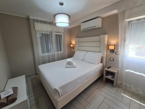 里米尼Nero D'Avorio Apartments的卧室配有白色的床和窗户。