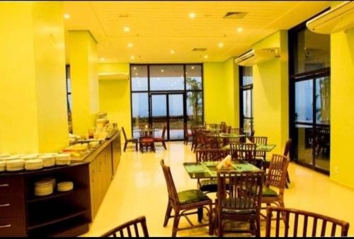 马瑙斯Tropical Executive Vista pra Praia的用餐室设有桌椅和黄色的墙壁