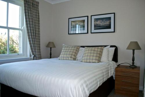 奥古斯都堡尼斯湖旅馆的卧室配有白色床、两盏灯和一扇窗户。