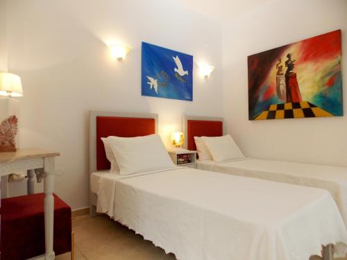 考考纳里斯Skiathos Driades的一间卧室设有两张床,墙上挂着一幅画