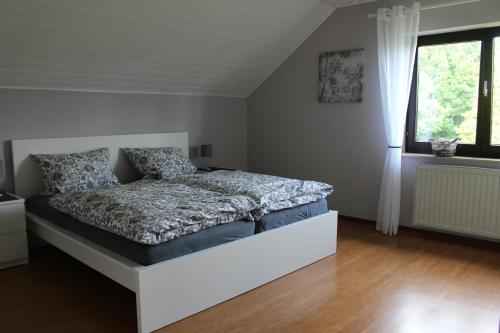 尼德根Ferienwohnung Eifelbrise的一间带床的卧室,位于带窗户的房间内