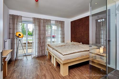 新明斯特Hotel aanders的一间卧室设有一张床和一个玻璃淋浴间