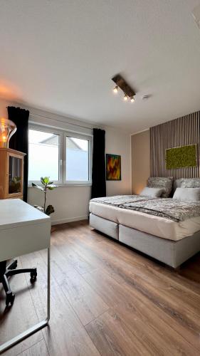 奥尔登堡Ferienhaus Oldenburg的一间卧室配有一张大床和一张书桌