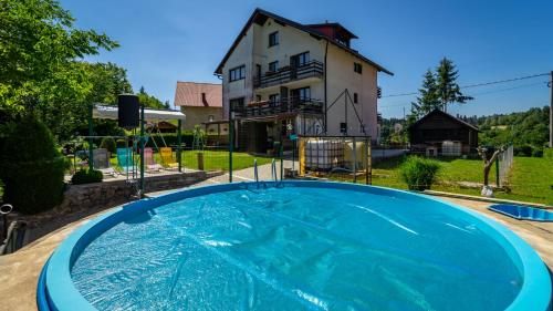科尔尼鲁格Guest House Raukar的一座大蓝色游泳池,位于房子前