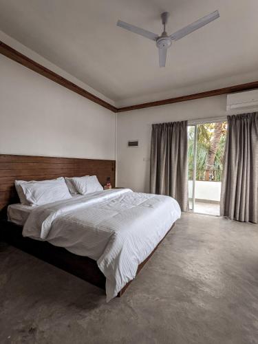 图鲁斯杜Dhoadhi Retreat的一间卧室设有一张大床和一个大窗户