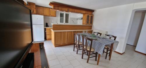 波多河丽Villa Madenia的厨房配有桌椅和冰箱。