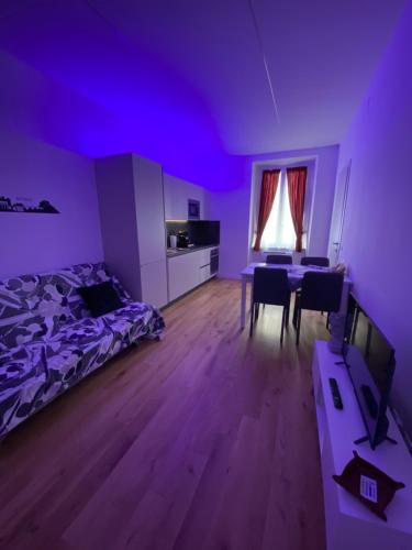 罗马Cavour Home的紫色的客房配有一张床和一张桌子及椅子