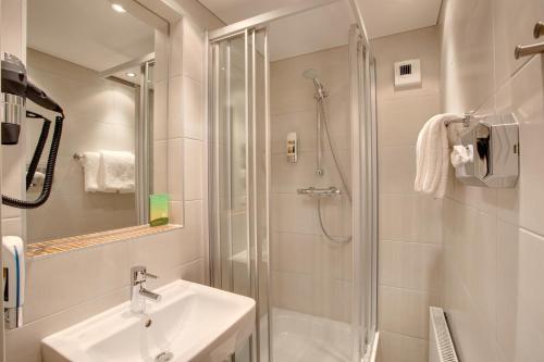 萨尔茨堡萨尔茨堡市中心梅宁阁酒店的白色的浴室设有水槽和淋浴。