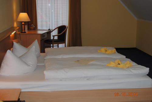 施普伦贝格施塔特施普伦贝格酒店的一张铺有白色床单和黄色鲜花的床