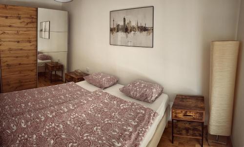 维也纳LUMA Apartment near Schönbrunn with parking的一间卧室配有一张床、一盏灯和一张桌子