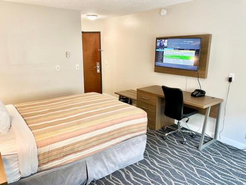 希尔斯伯勒希尔斯伯勒沙丘汽车旅馆的酒店客房配有一张床、一张书桌和一台电视。