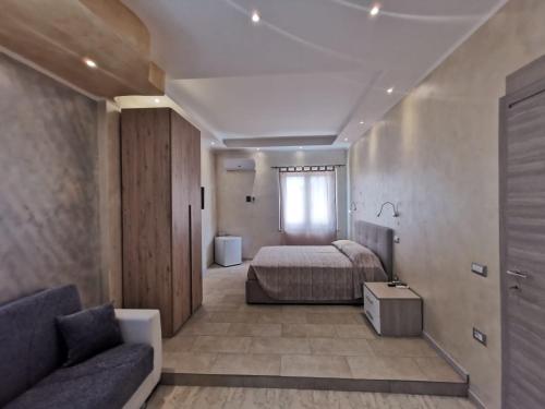 奇亚Villa Bianca的一间卧室配有一张床、一张沙发和一个窗口