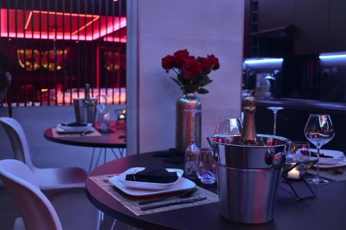 里沃萨尔特LES SECRETS ROOMS, LOVE ROOM DE LUXE AVEC JACUZZI的一张桌子,上面放着一瓶葡萄酒和一瓶鲜花