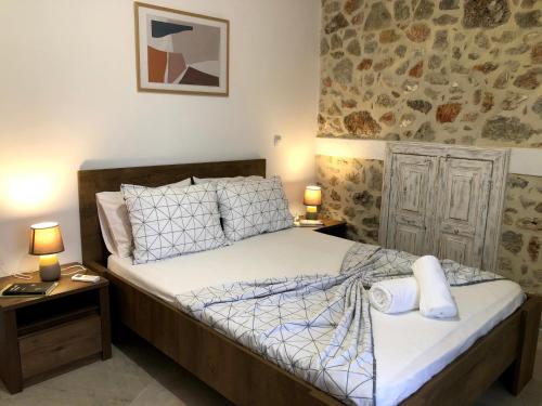 阿基欧斯尼古拉斯Oikia Stone House in seaside Kalo Chorio的一间卧室配有一张床和两个带灯的床头柜