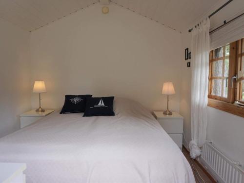 门斯特罗斯Holiday home Mönsterås VII的一间卧室配有一张带两盏灯的大型白色床。