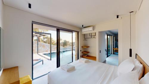 普洛马里翁DAELIA Villas的卧室设有白色的床和大窗户