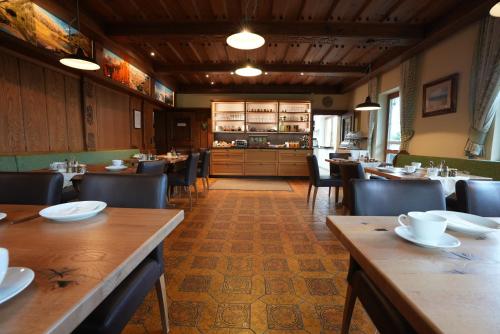 拉姆绍达赫斯坦Pension Dachsteinhof的一间带木桌椅的餐厅和一间厨房