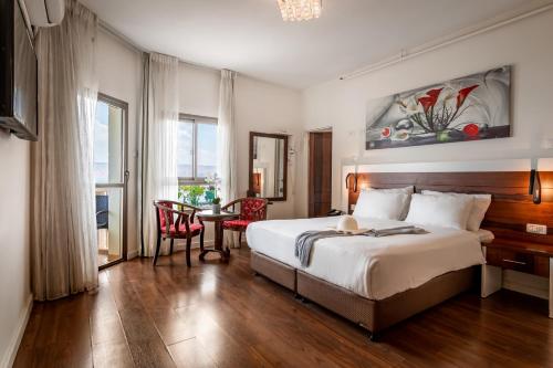 提比里亚特拉维夫度假屋酒店的一间卧室配有一张大床和一张桌椅
