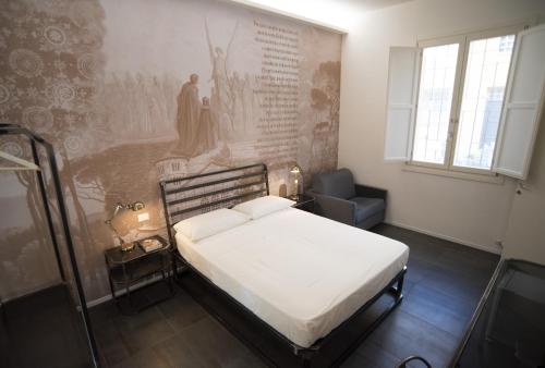 拉文纳BB LETTERARIO的卧室配有一张床,墙上挂有绘画作品