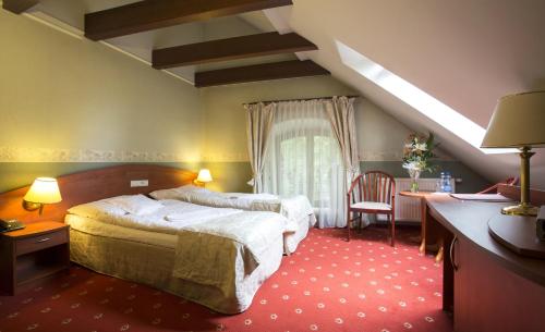 卢布林Hotel Restauracja Browar Lwów w Lublinie的酒店客房设有两张床、一张书桌和一个窗户。